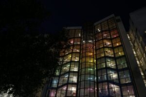 color image with photo of tower B illuminated with rainbow colors at night inside NOVA FCSH campus