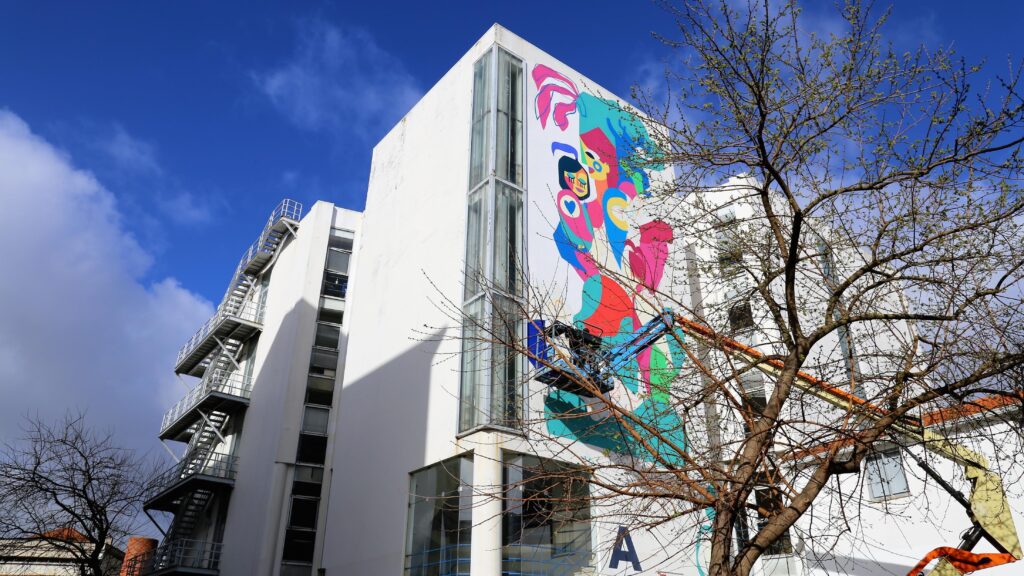 color image with photo of tower A showing a street art element in one of the walls inside NOVA FCSH campus